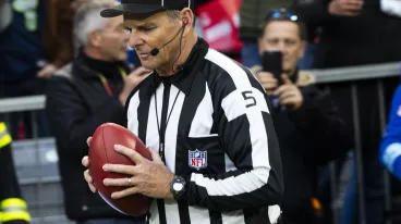 Ein NFL-Schiedsrichter mit einem Ball in der Hand während des Munich Game 2024