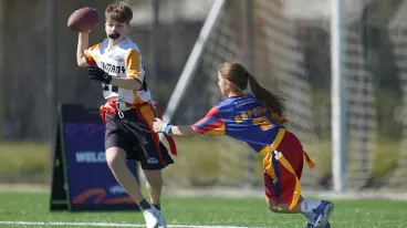 Eine Flag Football Spielerin versucht ihrem Gegenspieler die Flagge abzunehmen