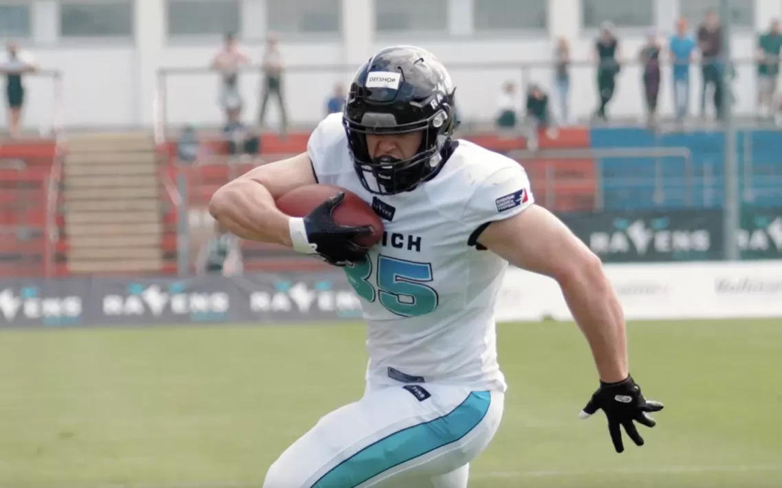 Ein Spieler der Munich Ravens trägt den Football bei einem Laufspielzug über das Feld