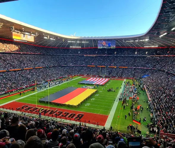 Spielfeld in der Münchner Allianz Arena mit den aufgespannten Flaggen der USA und Deutschland